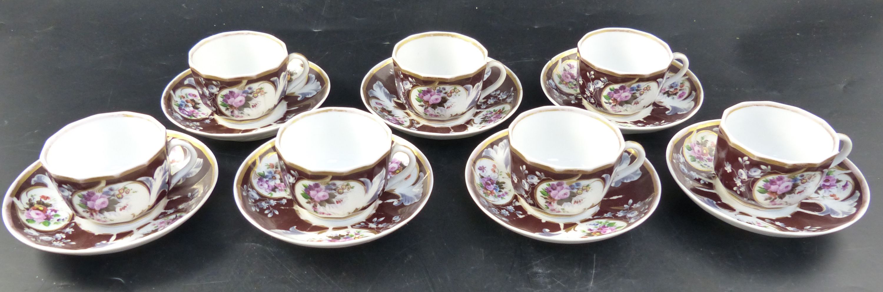 A set of seven Continental porcelain tea cups and saucers